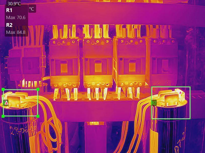 Imagem termografica de quadro eletrico com duas regioes marcadas registrando maximas de 70,6 e 84,8 graus Celsius