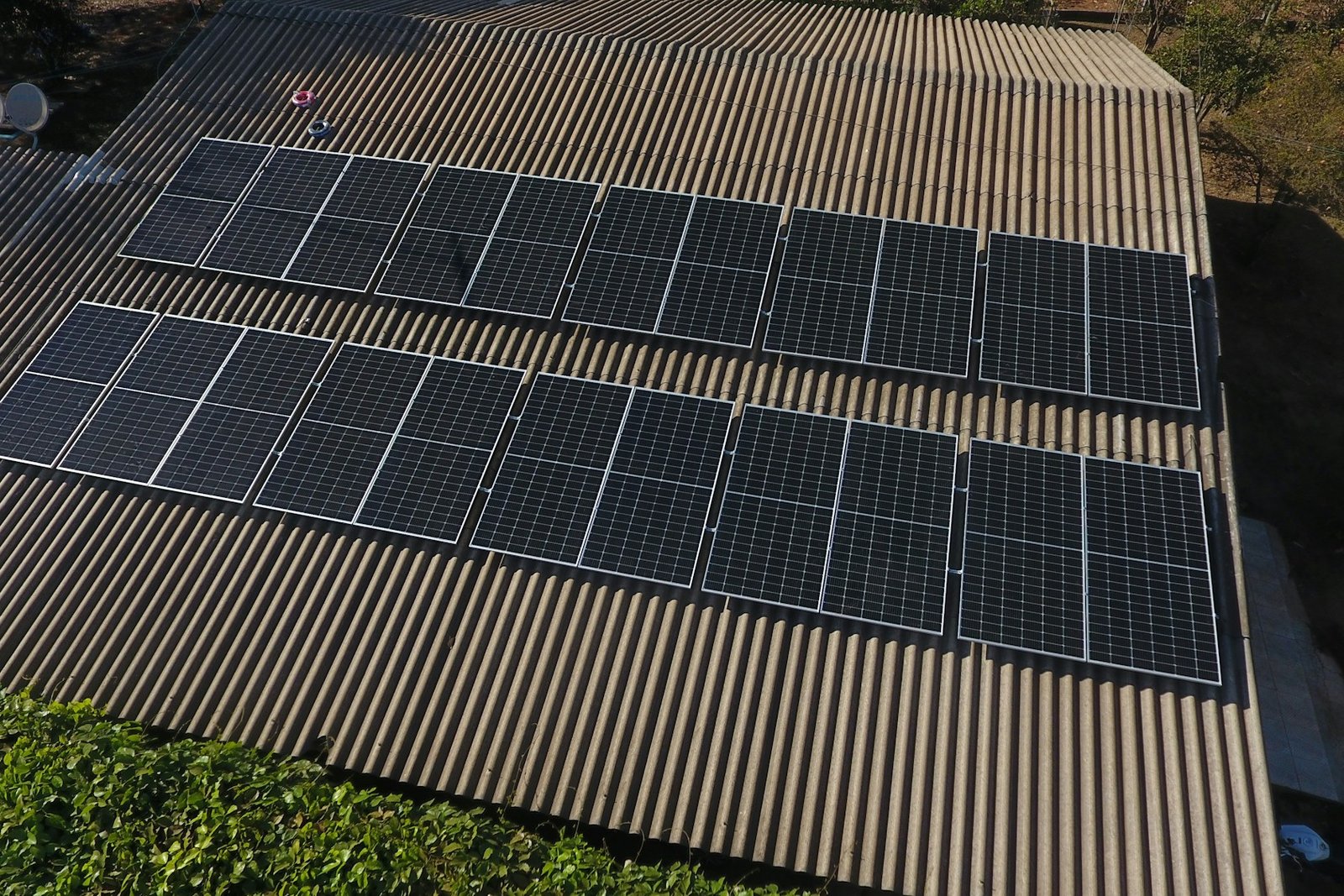 Vista aérea de módulos fotovoltaicos instalados em telhado